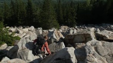 Sırtında sırt çantasıyla dağdan inen genç bir kadın macera yaşıyor.