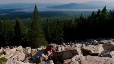 Sırtında sırt çantasıyla dağa çıkan genç bir kadın.