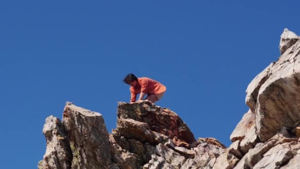 Joven teniendo una aventura - de pie en la montaña y mirando a su alrededor — Vídeo de stock