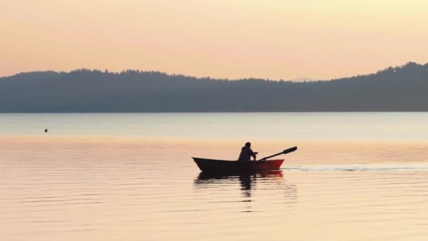 Hombre sentado en un barco y navegando en el río — Vídeo de stock