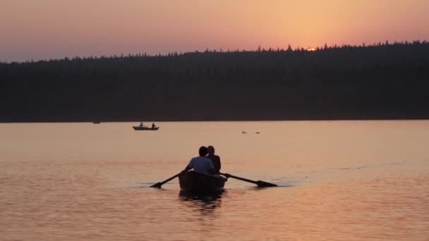 Een paar zeilen op de boot met behulp van peddels - mooie roze zonsondergang — Stockvideo