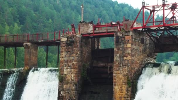 Waterdam midden in het bos - water valt onder de brug — Stockvideo