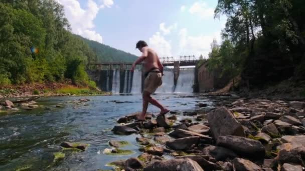 Mladý muž na dovolené - pozorování vodopádů v lese — Stock video