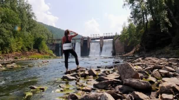 Ung kvinna på semester - titta på vattenfallen i skogen och aroung — Stockvideo