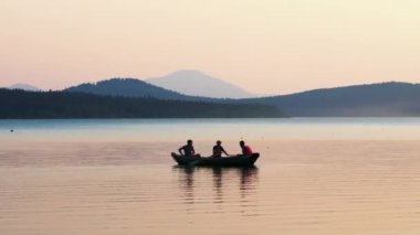 05-08-2020 KAZAN, RUSSIA: nehirde kayıkta oturan üç adam - dağların ve nehrin güzel manzarası