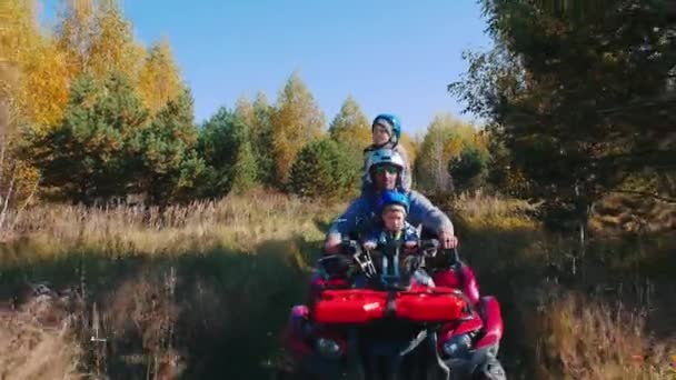 Seorang pria dengan anak-anaknya naik sepeda quad di lapangan musim gugur — Stok Video