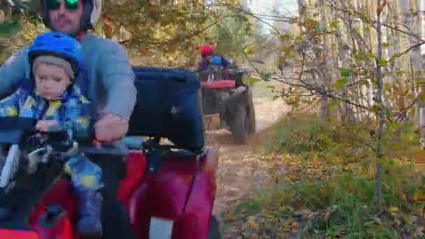 Big family rides quad bikes in the autumn forest — Stock Video