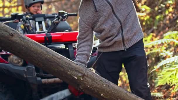 El bosque otoñal - el hombre toma la motosierra y comienza a cortar la madera — Vídeo de stock