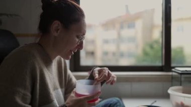 Rahat bir evde canlı kırmızı bir içeceğin tadını çıkaran genç bir kadın.