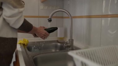 Ev aşçısı taze ürünleri yıkıyor, patlıcan, kabak ve dolma biber de dahil, akan suyun altında.