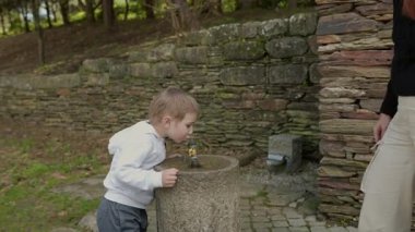 Anne ve oğlu bir taş çeşmenin üzerine eğilmiş, parkta tatlı su içiyorlardı.