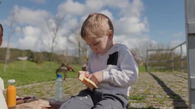 Aile çeşitli yiyecek ve içeceklerle pikniğin tadını çıkarıyor.