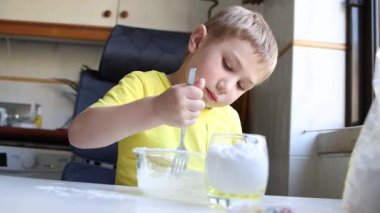 Çocuk dikkatli bir şekilde çatalla karıştığında malzemeleri bir kaseye doldurur.