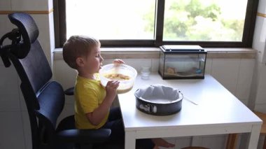 Çocuk kek hamurunu dikkatlice tavaya döker, lezzetli bir ziyafet hazırlar.