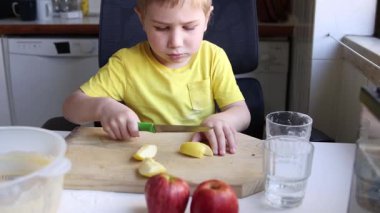 Çocuk elma kesmeyi öğreniyor, bağımsızlık ve mutfak becerilerini geliştiriyor