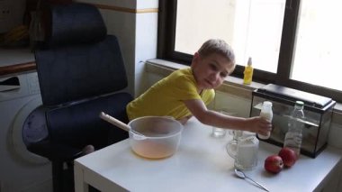 Elma suyuna elma püresi hazırlarken süt ekleyen bir çocuk