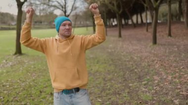 Parkta yalnız dans eden mutlu adam.