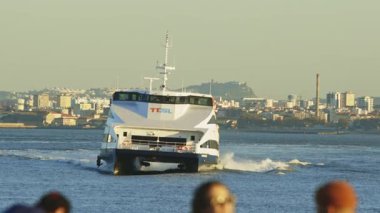 15 Kasım 2023, Lizbon, Portekiz toplu taşımacılık katamaranı arka planda Lizbon şehir manzarasıyla birlikte tagus nehrinden geçiyor.