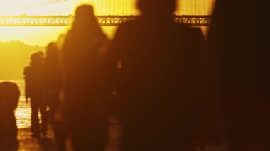 Günbatımında, Kaliforniya 'da arka planda Bay Bridge ile yürüyen tanınmamış bir kalabalık.