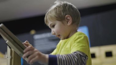 Bilim ya da çocuk müzesindeki interaktif ahşap sergi ile oynayan meraklı küçük çocuk.