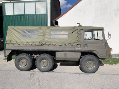 Gaenserndorf, Aşağı Avusturya - 01 Eylül 2025: Avusturya Silahlı Kuvvetleri 'nden Steyr-Puch Pinzgauer 712M askeri araç park etti. 3 koridor, zeytin yeşili muşamba kaplı yatak..