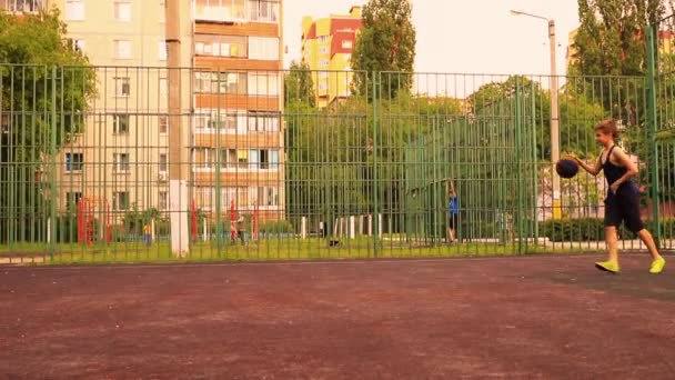 Les enfants jouent au basket sur l'aire de jeux de l'école sans masques — Video