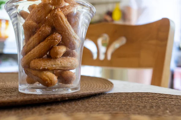 Una taza transparente de galletas savojardi se coloca sobre una servilleta sobre el fondo de una silla de madera — Foto de Stock