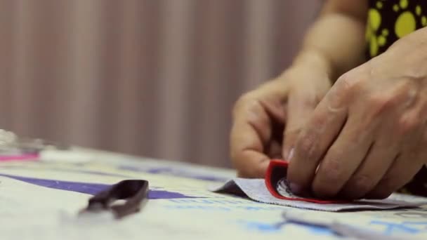 Een professionele naaister aan het werk in zijn werkplaats. Ze maakt haar werk met bekwame handbewegingen met draden en gereedschap. — Stockvideo