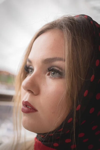 Retrato de uma menina em um lenço preto em bolinhas vermelhas. Menina europeia bonita em um terno branco em um ambiente urbano normal — Fotografia de Stock