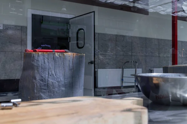 Dükkanda asılı et yığınları camın arkasındaki kancalarda.