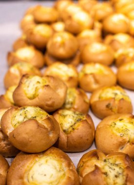 Tezgahın üzerinde bir sürü farklı dolgu malzemesi olan çörekler var.