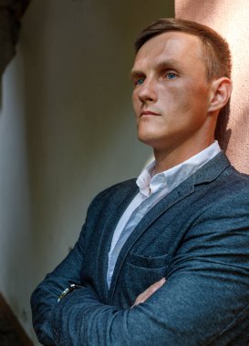 Beyaz gömlekli, Avrupalı yakışıklı bir adam köyde poz veriyor.