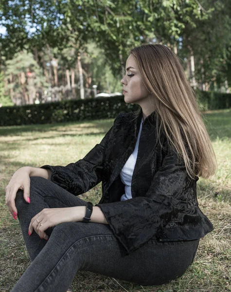 Krásná dívka s dlouhými vlasy a výraznýma očima pózuje v kožichu v parku — Stock fotografie
