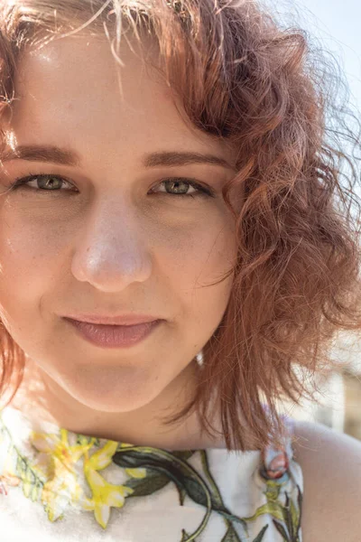 Vermelho de cabelos encaracolados menina em um vestido de verão posando na aldeia — Fotografia de Stock