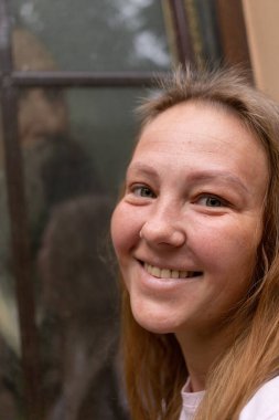 Beyaz tişörtlü ve kot pantolonlu güzel bir kız şehrin sokaklarında poz veriyor. Uzun saçları var ve makyajı yok. Eski şehrin mimarisi onun etrafında bir zemin.