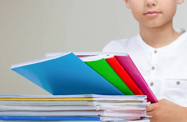 Ragazzo con libri colorati, quaderni e libri di testo che fanno i compiti — Foto Stock