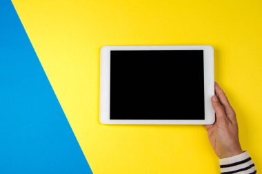 Tablet bilgisayarda renkli arka plan ile kadının el.