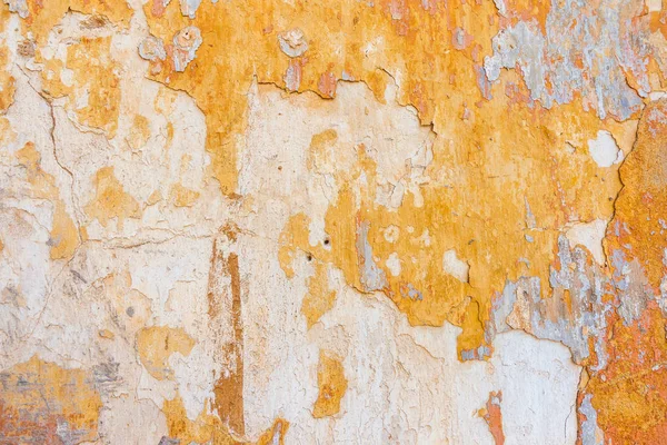 Velho rachado Weathered Shabby amarelo pintado gesso descascado parede fundo . — Fotografia de Stock