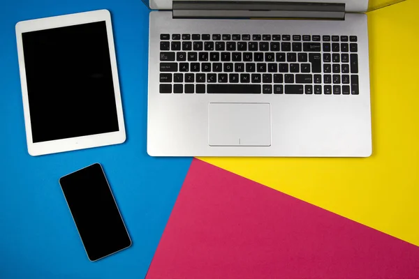 Dizüstü bilgisayar, tablet ve renkli arka plan üstünde hareket eden telefon. — Stok fotoğraf