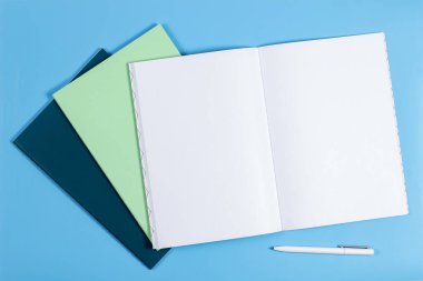 Açık Not defteri ve mavi arka plan üzerinde renkli Notebook