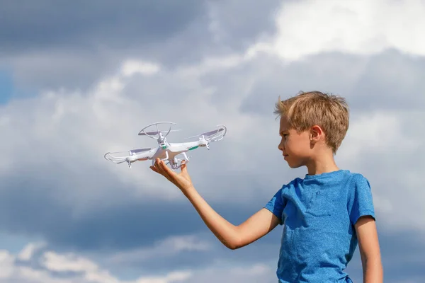 Niño jugando con dron al aire libre contra el cielo azul — Foto de Stock