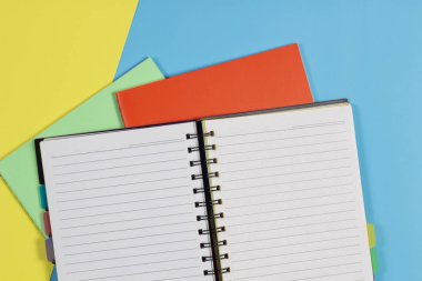 Açık Not defteri ve mavi arka plan üzerinde renkli Notebook