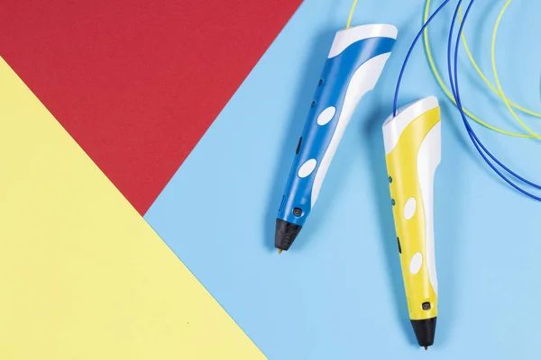 3d pens with colourful plastic filament on blue background — Stock Photo, Image