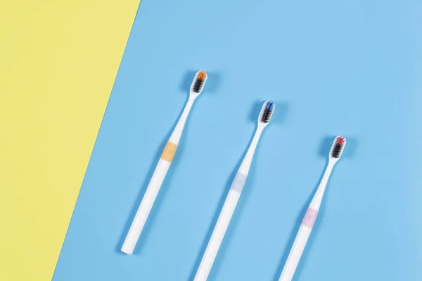 Toothbrushes on blue and yellow background. Top view — Stock Photo, Image