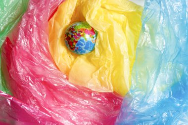 Küçük dünya arasında bir yığın plastik torba. Plastik aşırı kullanımı sorun kavramı