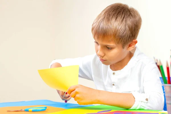 Dětské stříhání barevný papír s nůžkami v tabulce — Stock fotografie
