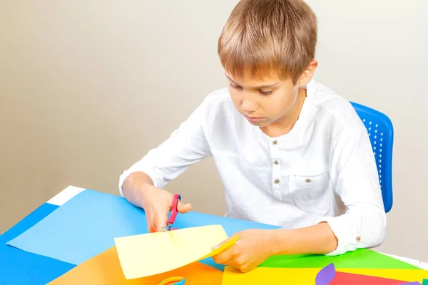 Renkli kağıt masada makasla kesme çocuk — Stok fotoğraf