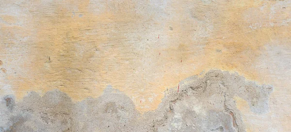 Dokulu grunge arkaplanı. Çok katmanlı çatlak kaplamalı eski duvarlar. Sarı duvarda derin desenli Grunge dokusu