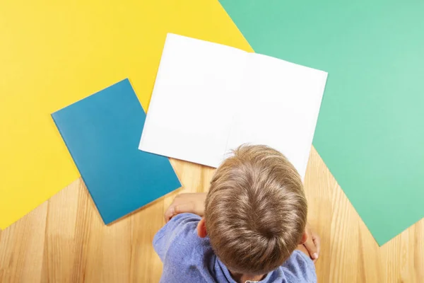 Kid with colorful books notebooks reading and doing homework — Stock Photo, Image