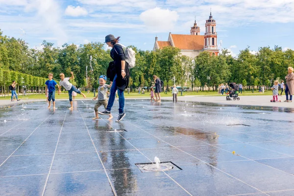 리투아니아 빌뉴스, 7 월 6 2018: 사람 Lukiskes 광장에서 뜨거운 여름 날에 도시 물 분수에서 놀고 재미 있다 — 스톡 사진